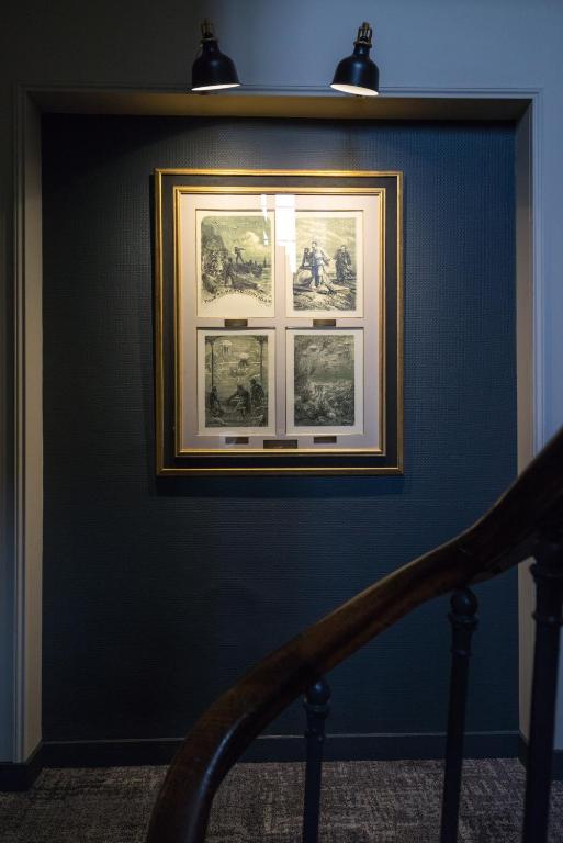 a framed picture on a blue wall with a staircase at Hotel Voltaire Opera Nantes Centre in Nantes
