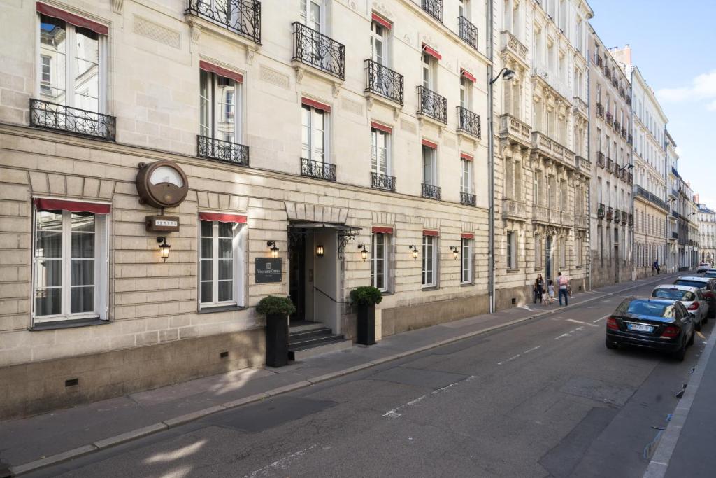 a building with cars parked on the side of a street at Hotel Voltaire Opera Nantes Centre in Nantes