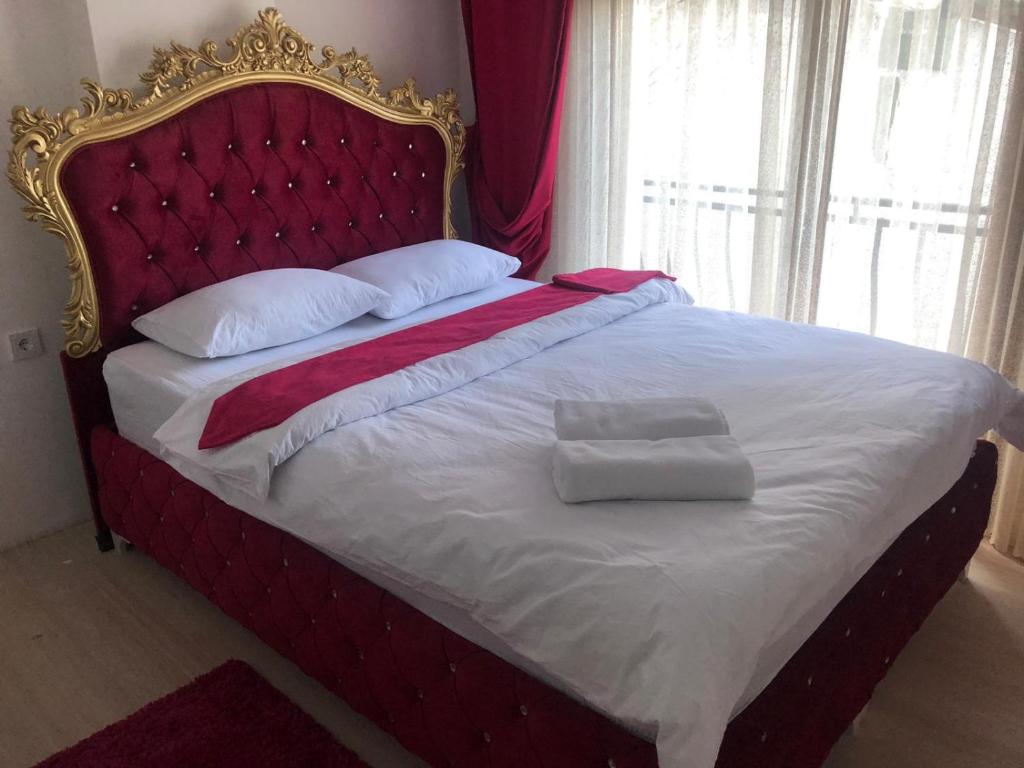 Bett mit rotem Kopfteil und zwei Kissen darauf in der Unterkunft Luxx Suite Mecidiyeköy in Istanbul