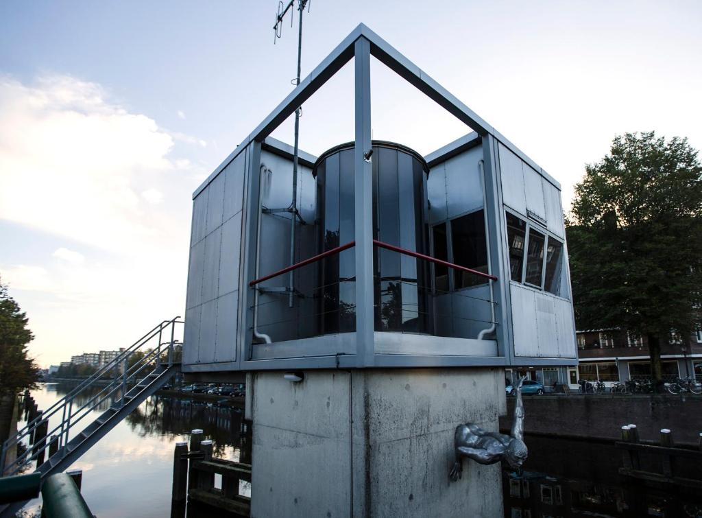 a glass house on top of a body of water at SWEETS - Wiegbrug in Amsterdam