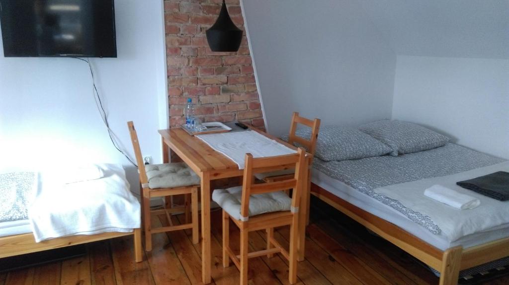 Cette chambre comprend un lit, une table et des chaises. dans l'établissement Kwatery u Eve, à Dziwnów