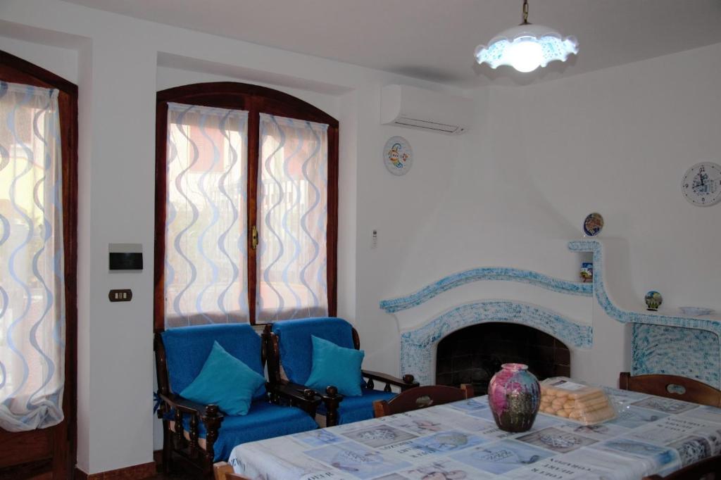 uma sala de jantar com uma mesa e cadeiras e uma lareira em Confortevole appartamento a pochi passi dal mare em Cala Gonone