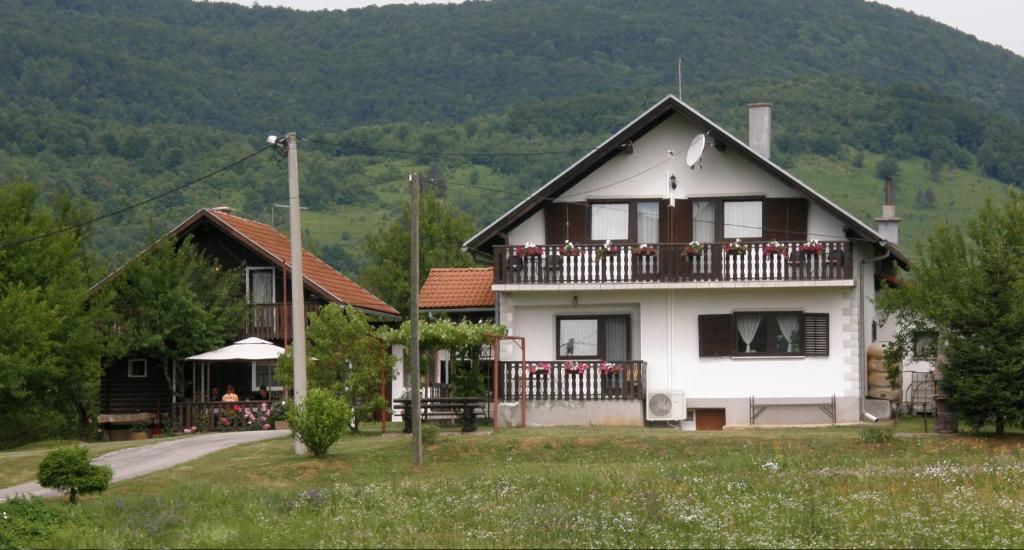 a white house with a balcony and a mountain at House Viktoria in Seliste Dreznicko