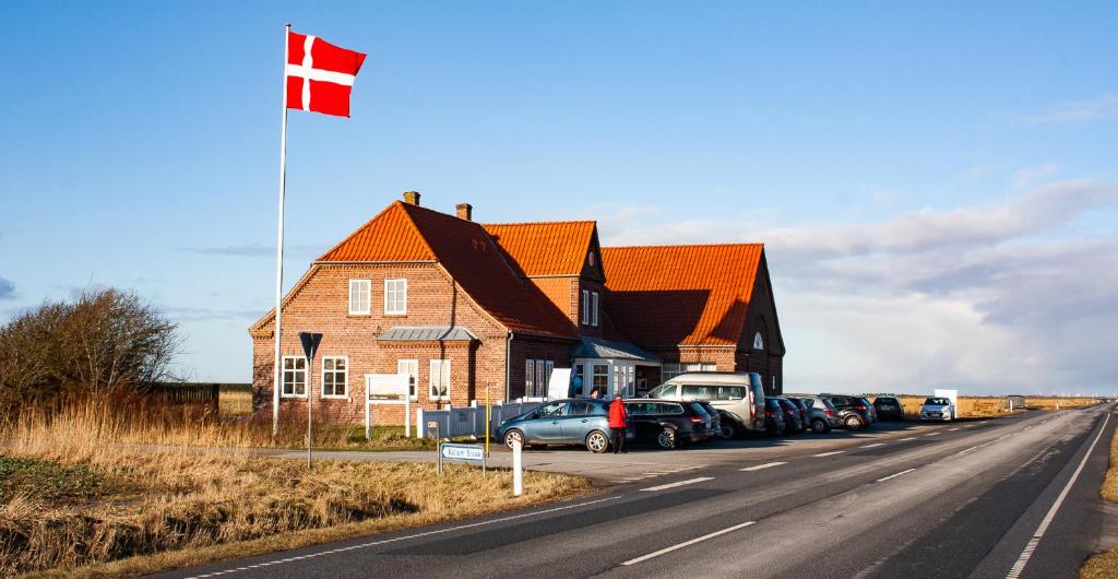 a house with a flag on the side of the road at Ballum Slusekro in Ballum