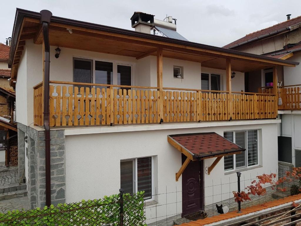 una casa con una terraza de madera encima en Guest house Grahlyov en Sapareva Banya