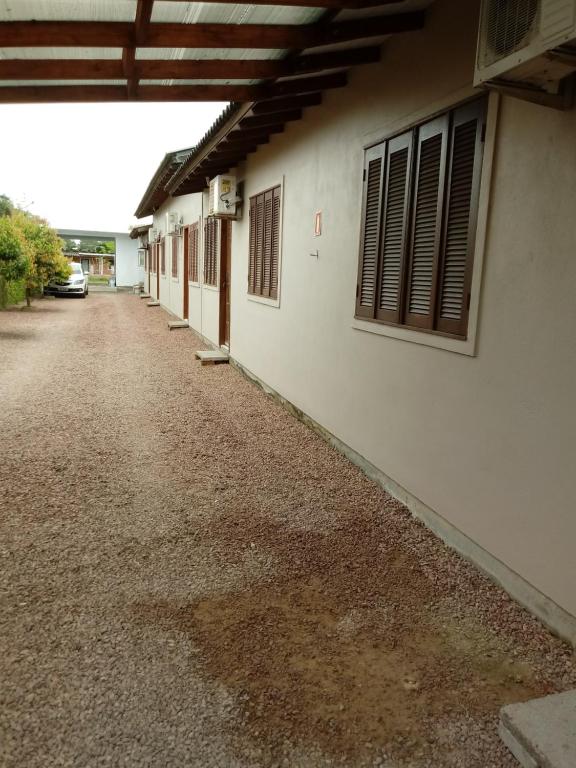 an empty road next to a white building at Pousada Recanto Rocha in Arambaré