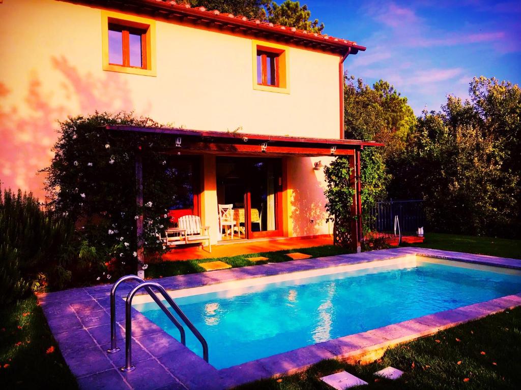 uma casa com piscina em frente a uma casa em Villa nel verde | civico 2 em Uzzano