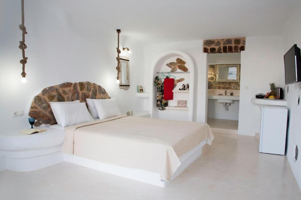 カルテラドスにあるサカス レジデンスの白いベッドルーム(大型ベッド1台付)、キッチンが備わります。