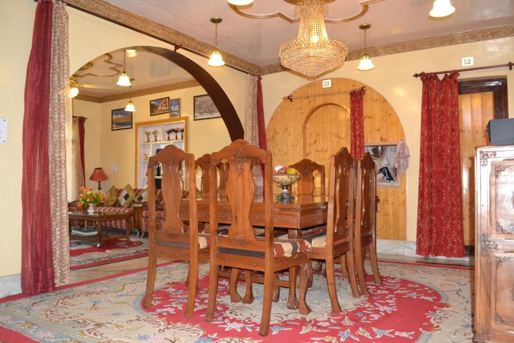 a dining room with a wooden table and chairs at Dilaram Guest House in Srinagar