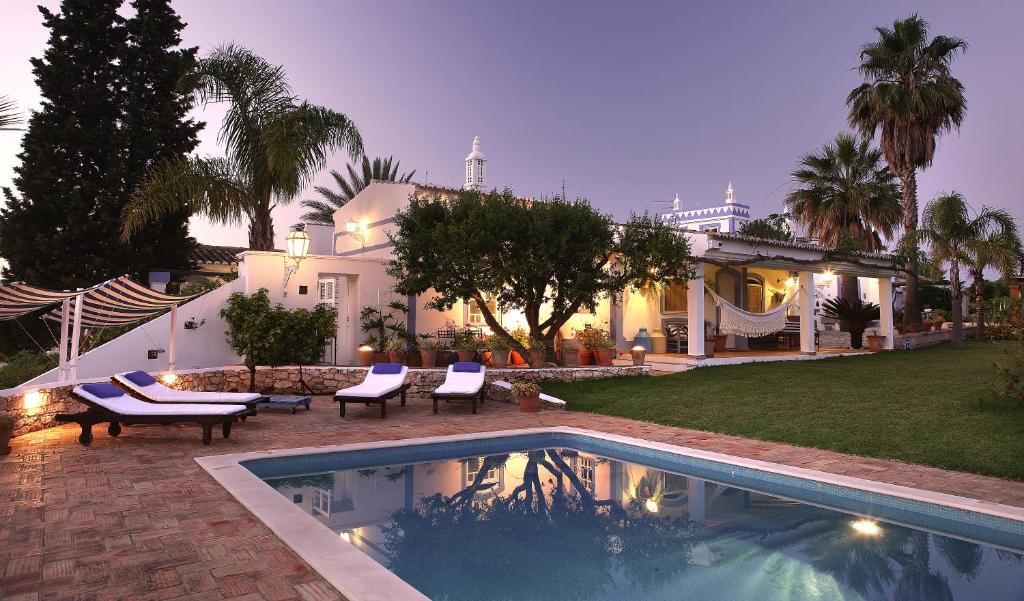 a house with a swimming pool in front of a house at Monte das Cortelhas in Guia