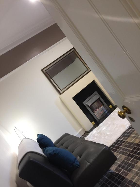 a living room with a couch and a fireplace at Water side flat in Hawick