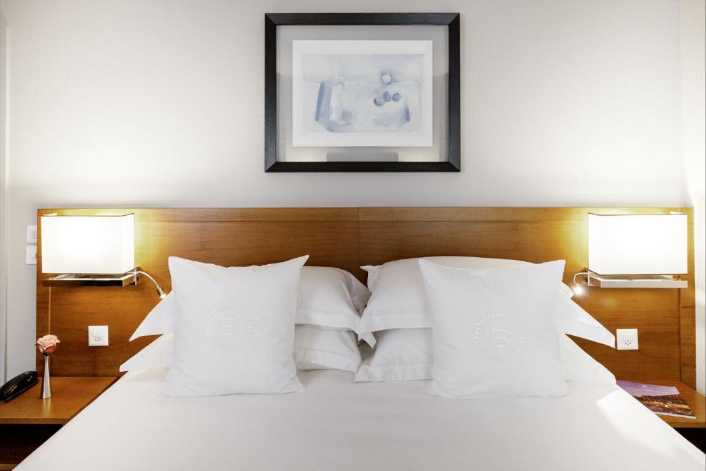 a bed with white pillows and a picture on the wall at EasyRooms ai Monti in Locarno