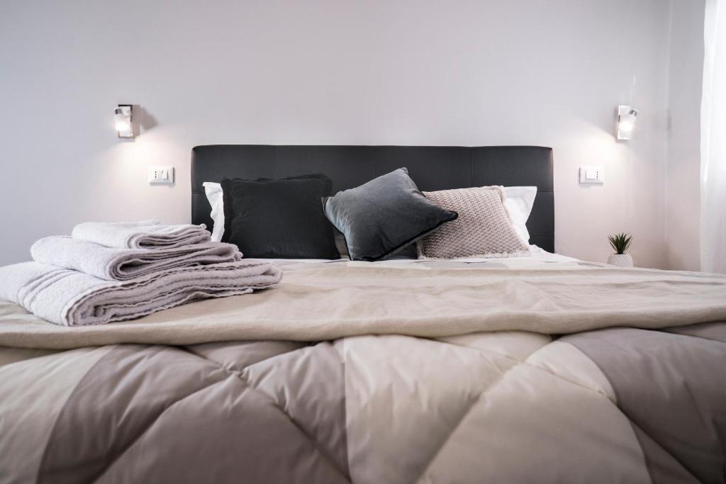 uma cama grande com cobertores e almofadas em B&B EL DUCHE em Empoli