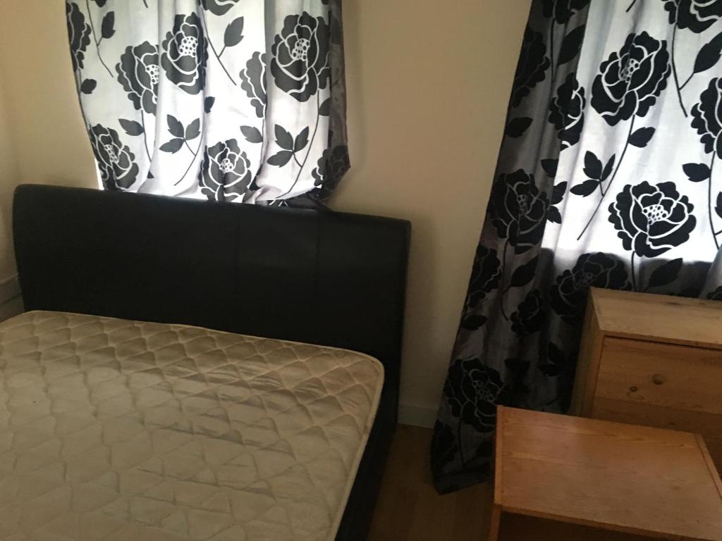 a bedroom with a bed and a black and white curtain at Seaside resort in Felixstowe