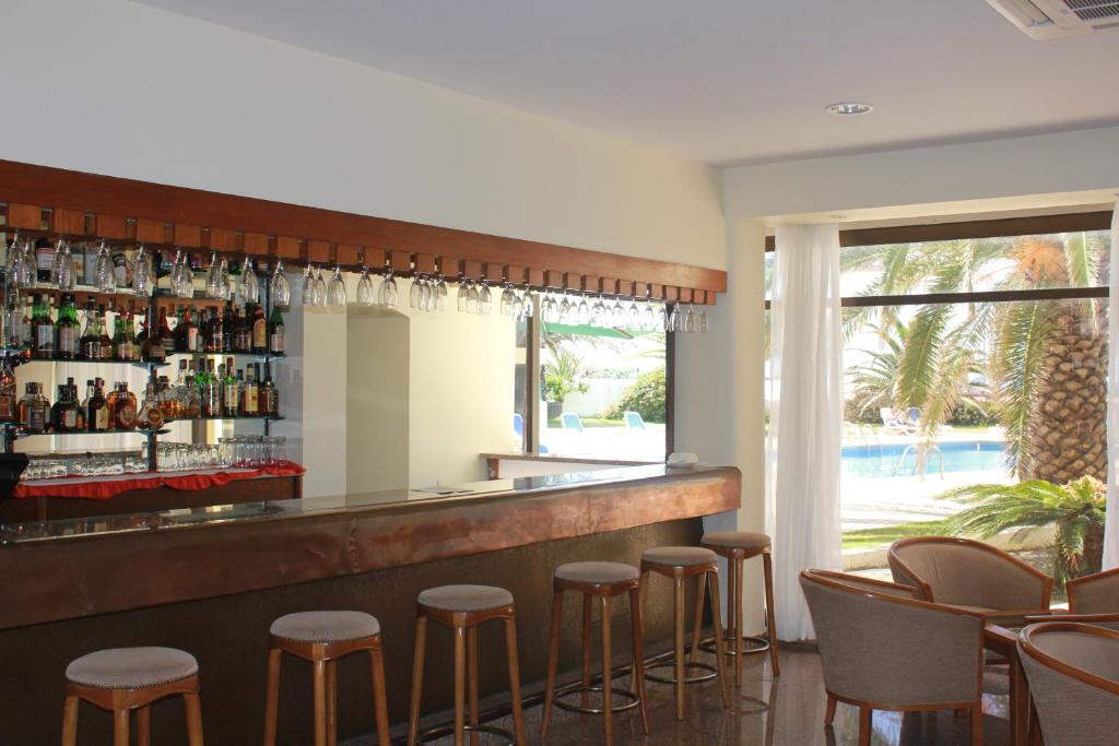 a bar with stools in a restaurant with a view at Hotel Caravelas in Madalena