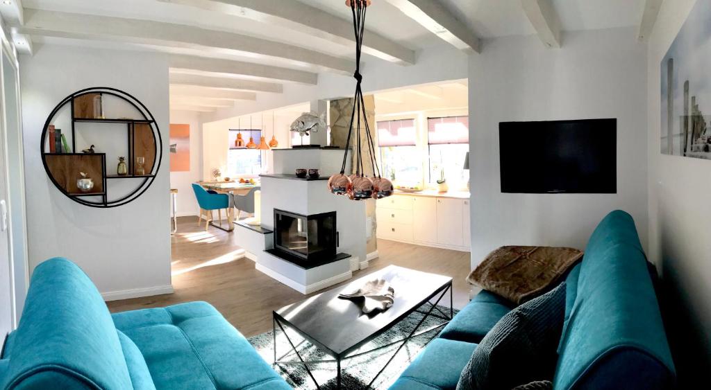 ein Wohnzimmer mit einem blauen Sofa und einem Kamin in der Unterkunft Ferienhaus am Dachsberg in Bad Saarow