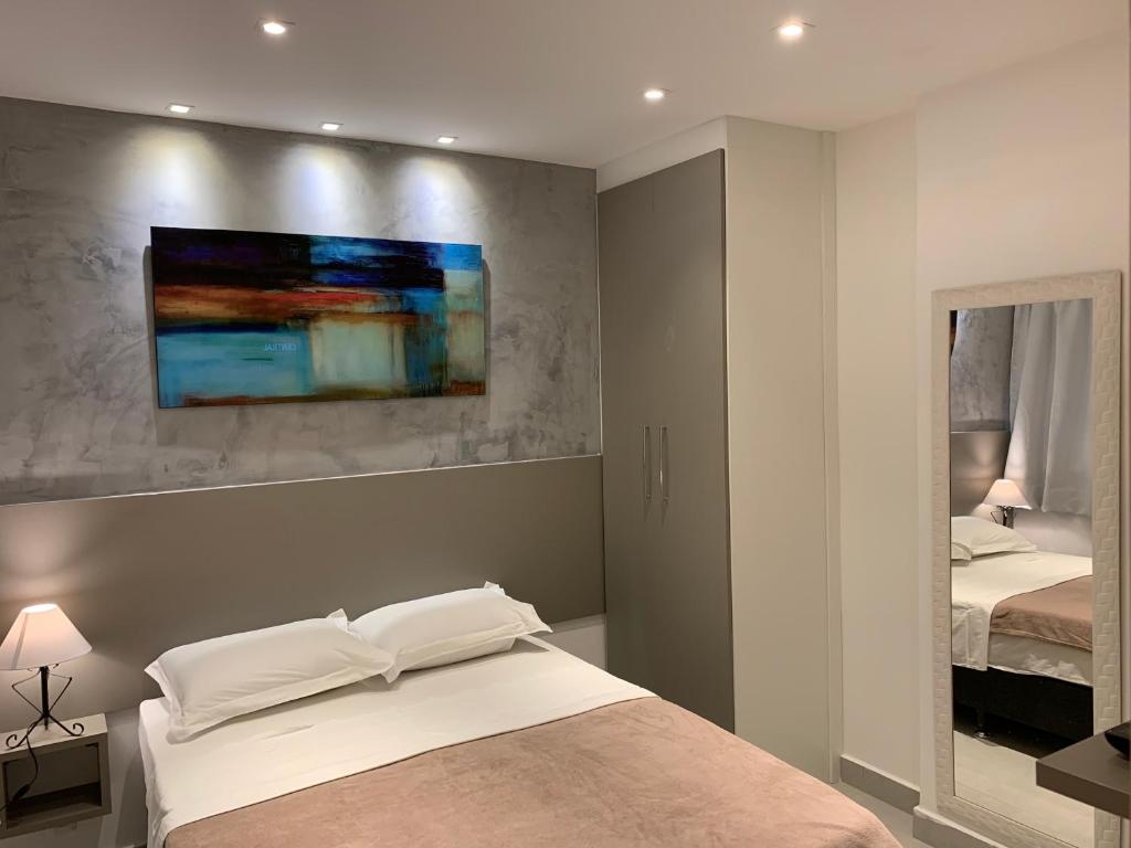 um quarto com uma cama e uma pintura na parede em The Best Apartment in Copacabana - Quarto e Sala no Rio de Janeiro