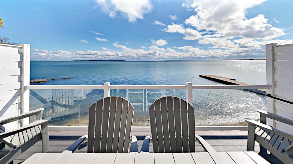 Duas cadeiras sentadas num alpendre com vista para o oceano em Put-In-Bay Waterfront Condo #108 em Put-in-Bay