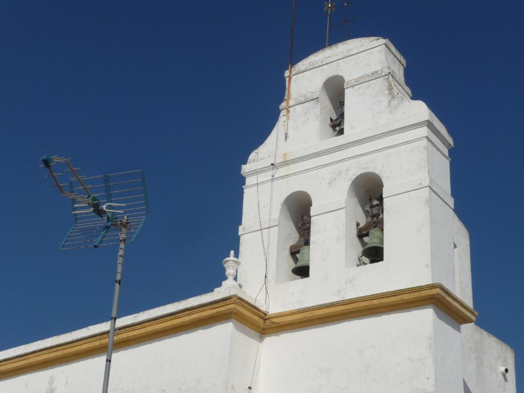 a white clock tower with two bells on it at Casa Sol in Vejer de la Frontera
