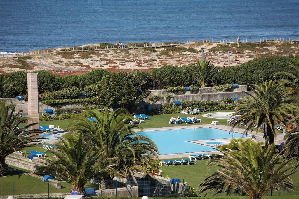 uma vista para uma piscina e para o oceano em Hotel Solverde Spa and Wellness Center em Vila Nova de Gaia