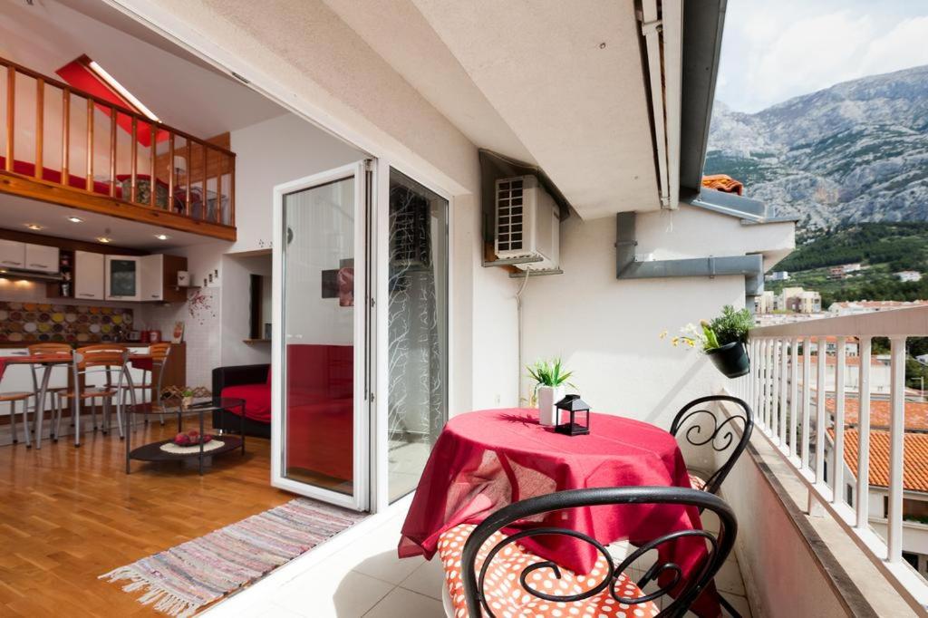 ein Balkon mit einem roten Tisch und Stühlen in der Unterkunft Litorian Makarska in Makarska