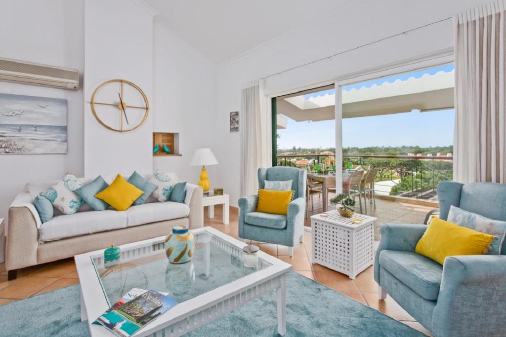 ヴィラモウラにあるSuperb, relaxing and tranquil 3 bed Apartment in Central Algarveのリビングルーム(青い椅子、ガラスのテーブル付)