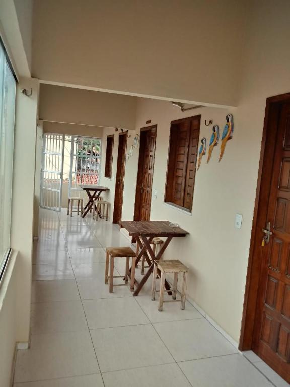 a room with a table and benches and tables at Suítes Canaã in Canoa Quebrada