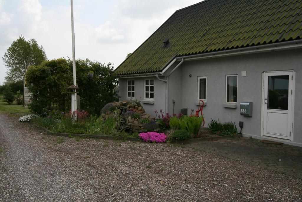 una casa blanca con flores delante en Guldbergs Guesthouse, en Kerteminde