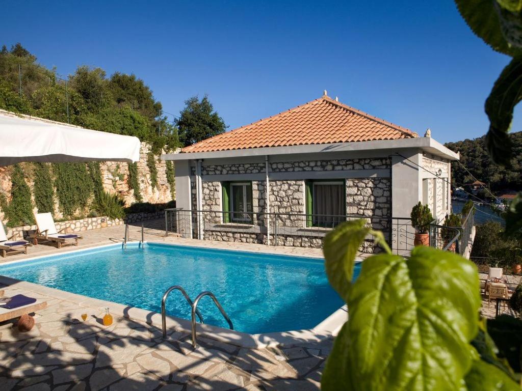 a villa with a swimming pool and a house at C. Katopodis Mansion in Meganisi