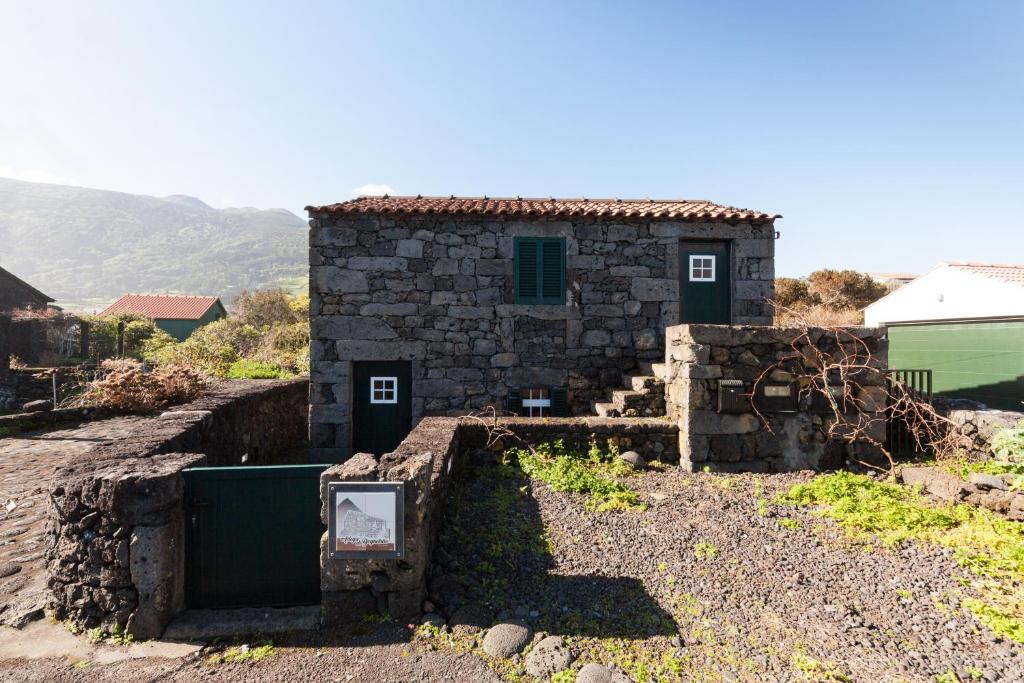 Prainha de BaixoにあるAdega do Boqueiraoの目の前に看板が立つ小さな石造りの建物