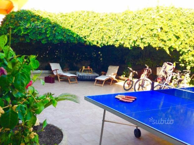 una mesa de ping pong azul en un patio con sillas en Sea Life Maganuco, en Marina di Modica