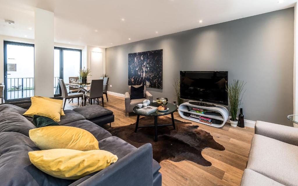 sala de estar con sofá y TV de pantalla plana en Stunning 3 Bedroom Duplex By Kings Cross & Camden, en Londres