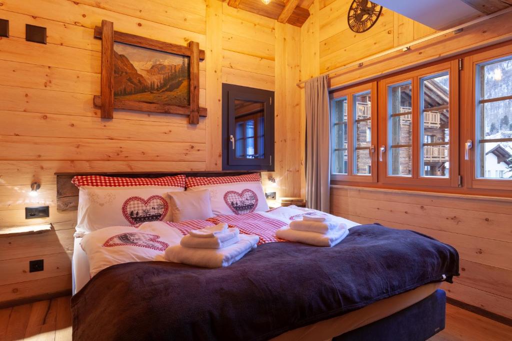 sypialnia z łóżkiem w drewnianym domku w obiekcie Chalet Schuler w mieście Zermatt