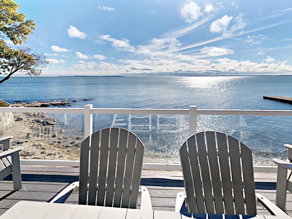 - deux chaises assises sur une terrasse donnant sur l'océan dans l'établissement Put-in-Bay Waterfront Condo #111, à Put-in-Bay