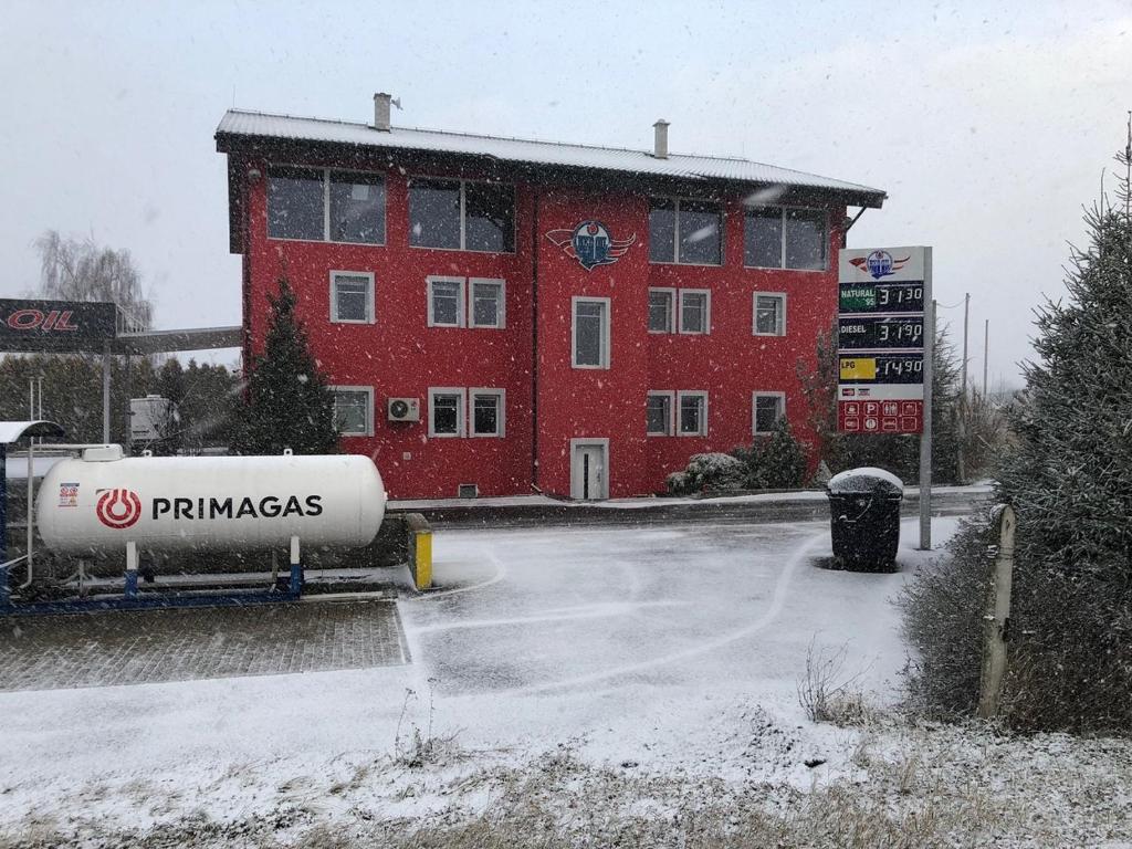 ein rotes Gebäude mit einem Tank davor in der Unterkunft Motel Red Oil in Lovosice