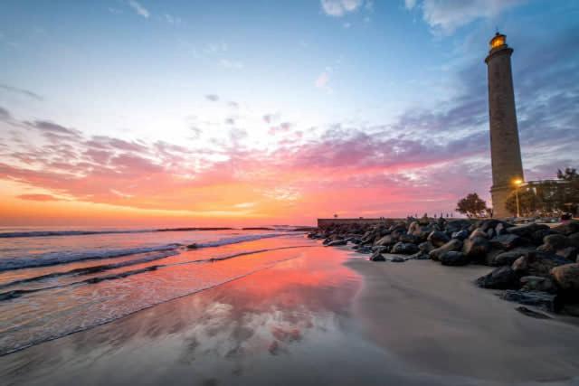 ein Leuchtturm am Strand mit Sonnenuntergang in der Unterkunft "Flora B&B "- Rooms in Privat Home in Maspalomas