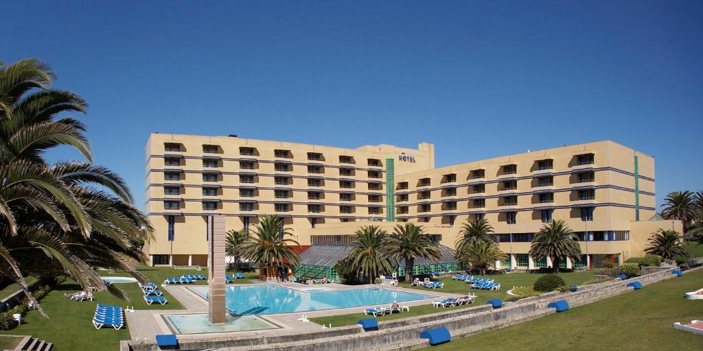 a hotel with a swimming pool in front of a building at Hotel Solverde Spa and Wellness Center in Vila Nova de Gaia