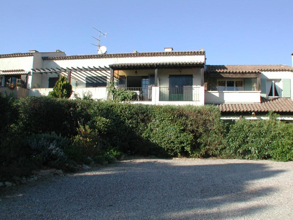 a house with a hedge in front of a building at Les Arbousiers in La Croix-Valmer