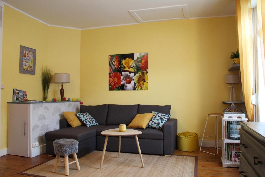 uma sala de estar com um sofá e uma mesa em Le Kooka em Arras