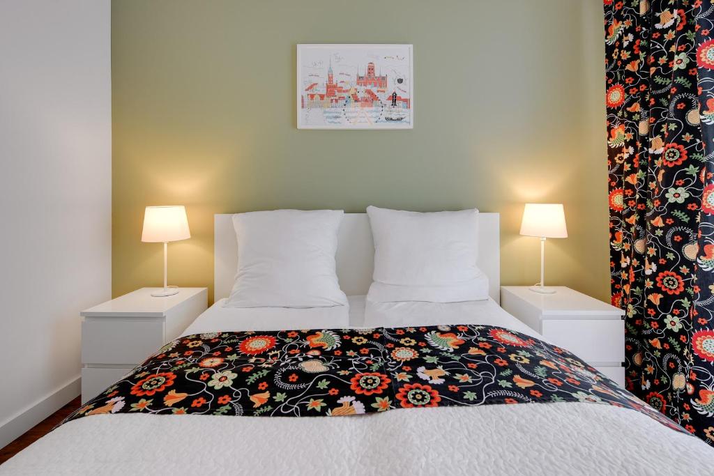 格但斯克的住宿－Apartment TriApart Big Blue，一间卧室配有一张带花卉毯子的床
