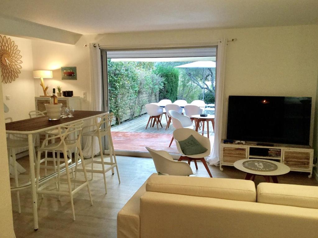 sala de estar con sofá y TV en Maison Centre village St Tropez Avenue Foch, en Saint-Tropez