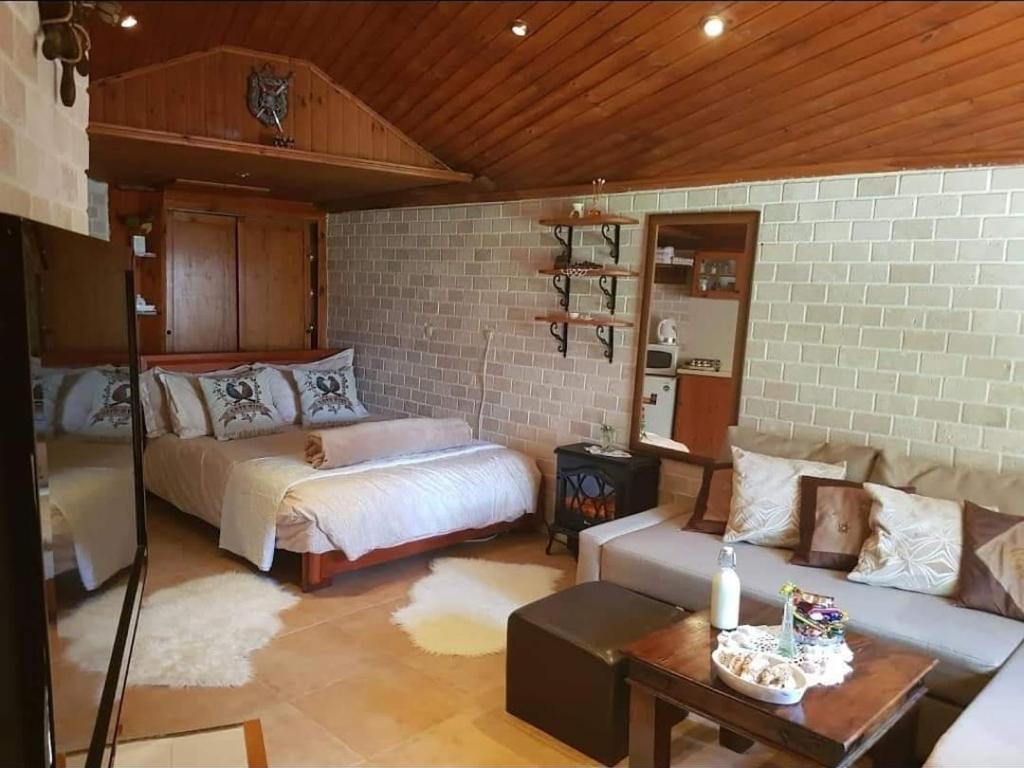 een slaapkamer met een bed en een bank in een kamer bij Czarina Cabin הבקתה הקיסרית in Caesarea