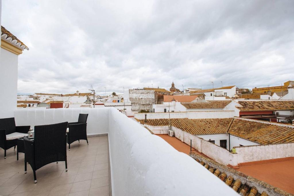 a balcony with black chairs and a view of a city at Piso Con Terraza y Vistas Espectaculares in Carmona