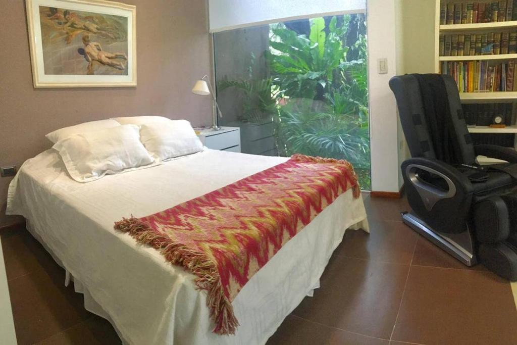 1 dormitorio con 1 cama, 1 silla y 1 ventana en Casa del Chivato en Paraná