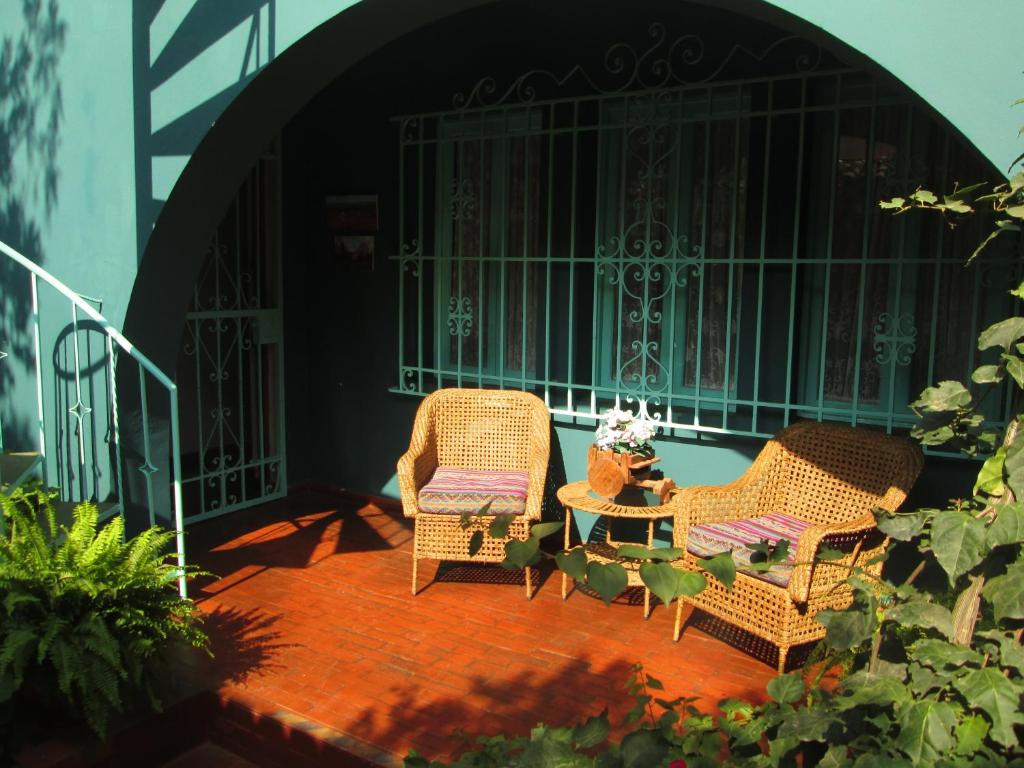 two wicker chairs and a table on a patio at La Casona Azul in Lima