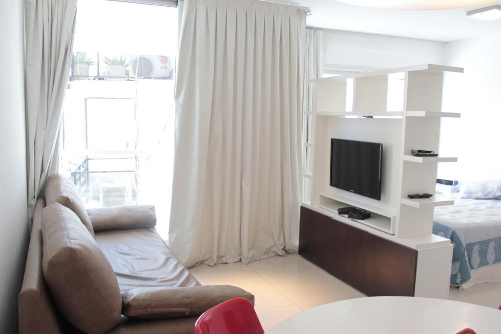 - un salon avec un canapé, une télévision et un lit dans l'établissement Palermo nuevo - Embajada USA, à Buenos Aires
