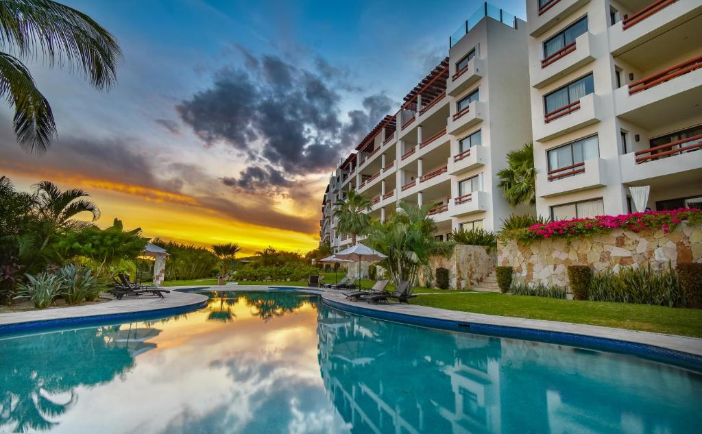 un hotel con piscina frente a un edificio en Alegranza Luxury Resort - All Master Suite en San José del Cabo