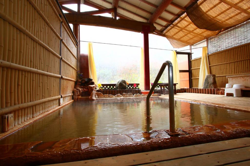 einen Pool mit Wasser in der Mitte eines Raumes in der Unterkunft Ramune Onsen Senju no Sato in Kirishima