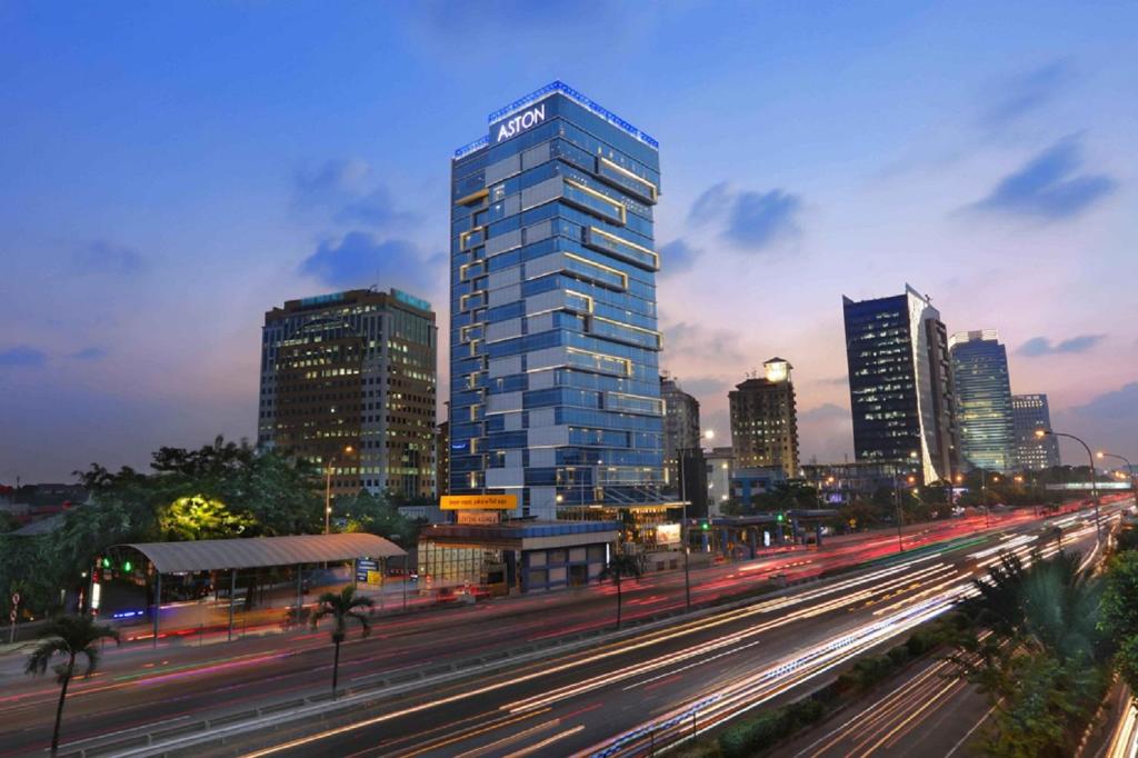 Un alto edificio blu in una città trafficata di ASTON Priority Simatupang Hotel and Conference Center a Giacarta