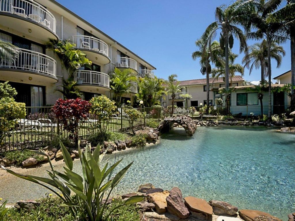 a swimming pool in front of a building at Allamanda 37 in Long Jetty